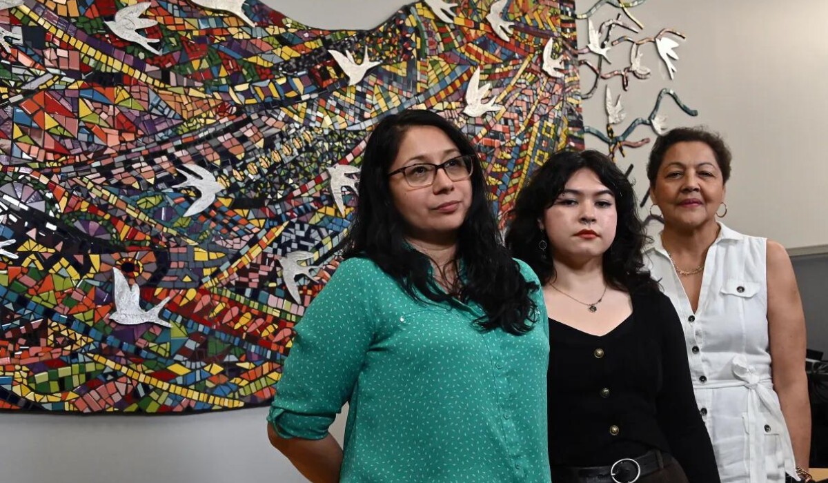 Three women stand beside each other in solidarity